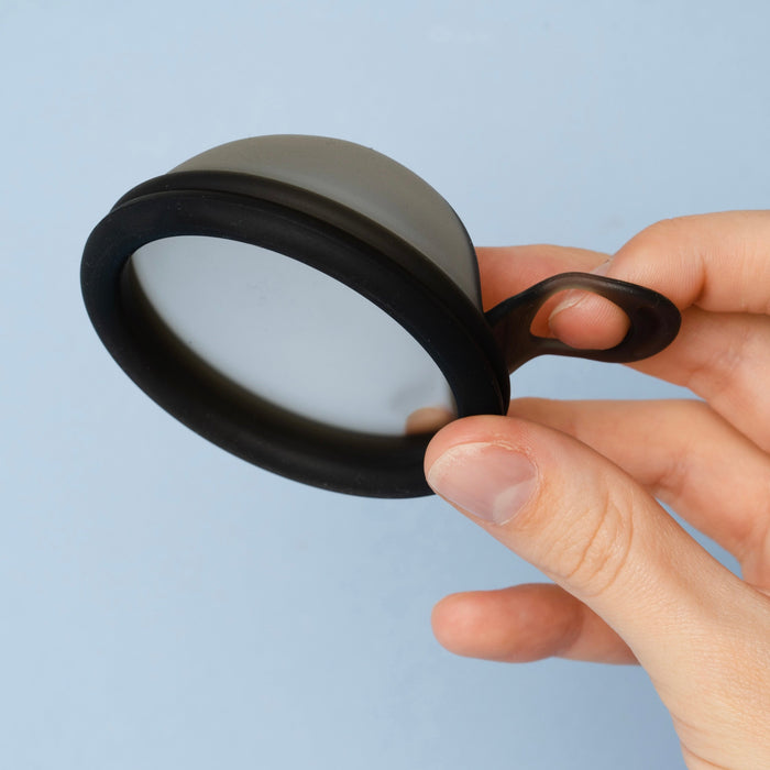    Bohokiwi black menstrual disc with removal ring held by hand