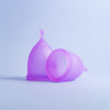 Two Lavender bohokiwi reusable menstrual cups, one upright and one on its side
