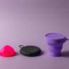 Bohokiwi Neon Pink menstrual disc with Black round carrier case and Purple collapsible steriliser