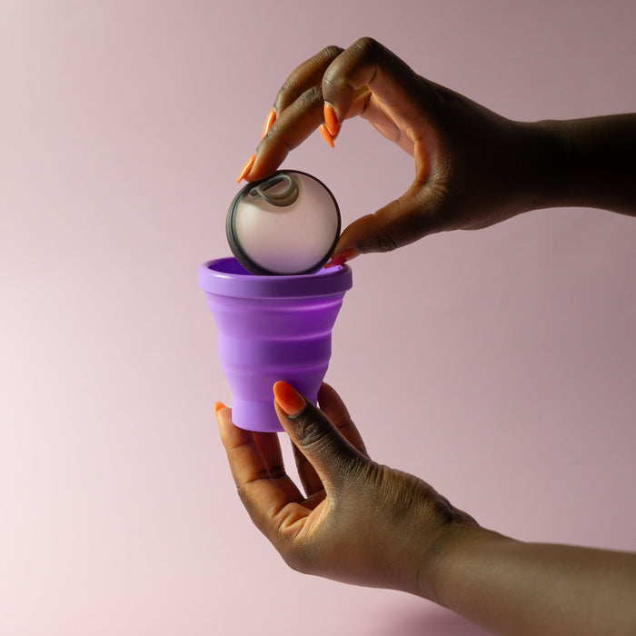 Bohokiwi menstrual disc being placed into a Purple collapsible steriliser