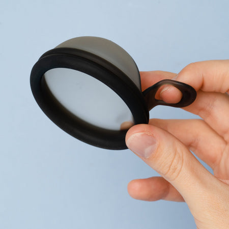     Bohokiwi Midnight Black menstrual disc held in hand showing the removal ring
